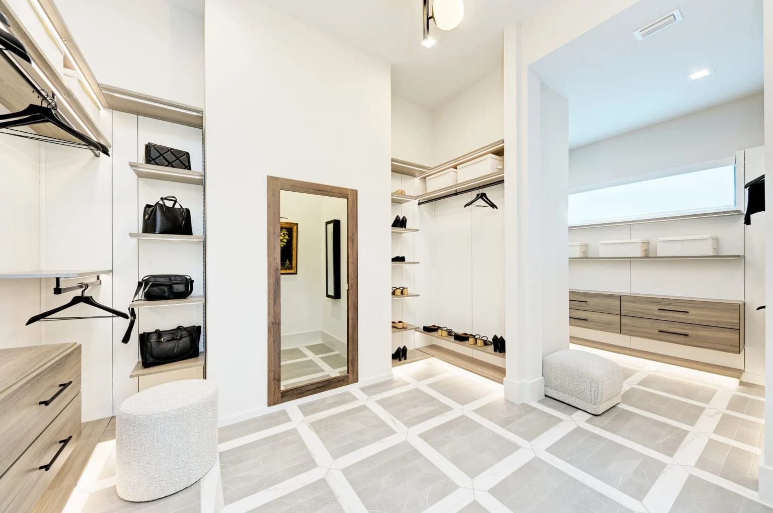 A walk-in closet with a full-length mirror set into a concealed door.