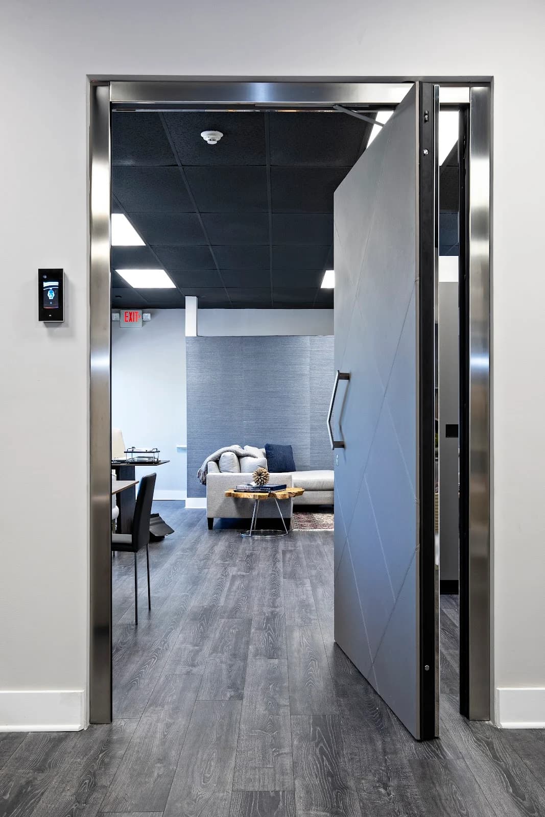 An open security door in a showroom, with a metal frame and a wall-mounted access reader.