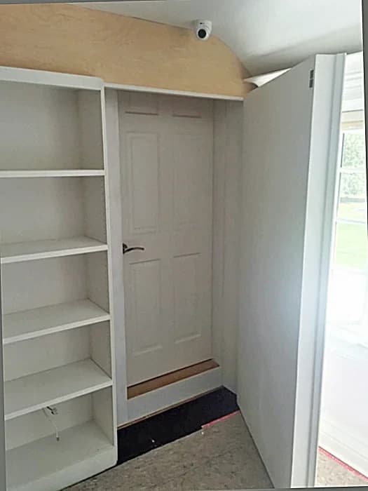 White closet shelving beside an open internal doorway.